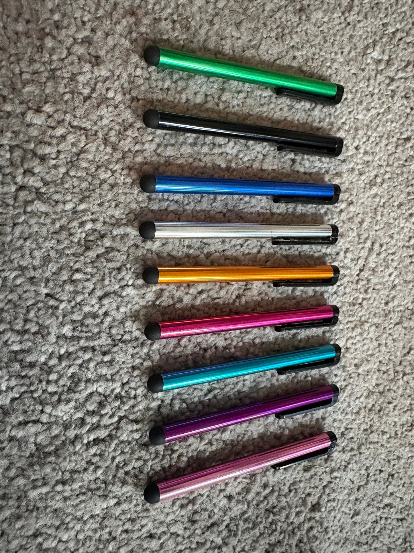 Row of colorful pens on a textured surface